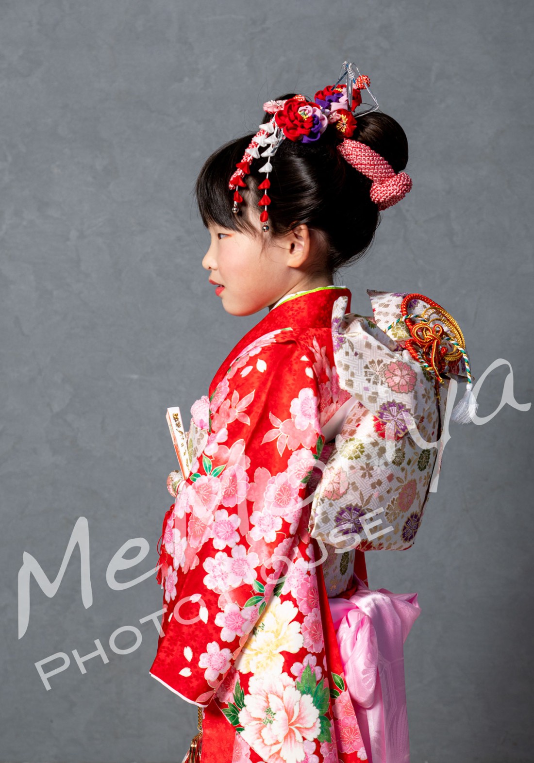 6歳のお子様が、七五三のお祝いの撮影に来店されました。日本髪をご希望でしたので、日本髪を結うことができる美容師さんをお呼びしました。日本髪は施術に1時間弱かかりますが、できあがりはとても素敵です。口紅の締めの一筆をママにお願いしました。そして、簪（かんざし）も最後の一つをママにお願いしました。（現在は、ヘアメイクは提携美容院カットハウスピックアップさんにお願いしています）